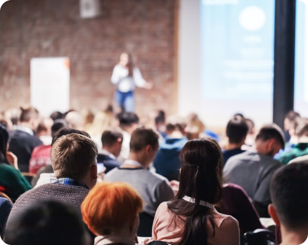 woman on stage speaking to an audience