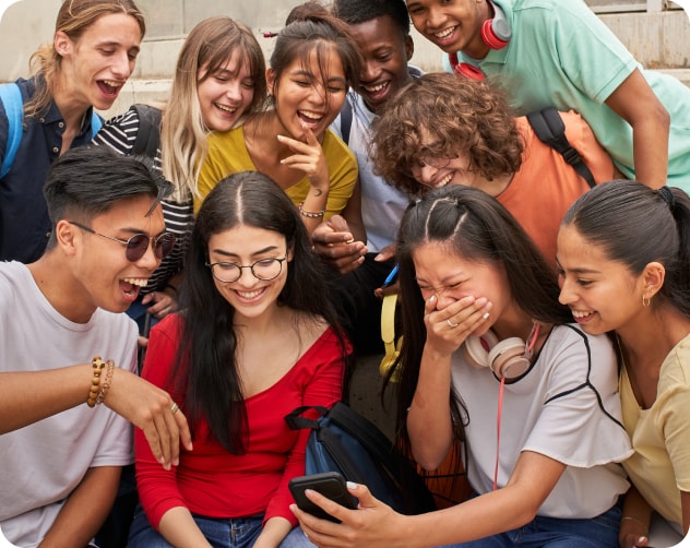 group of students laughing at cell phone