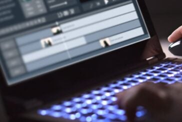 student editing video on laptop
