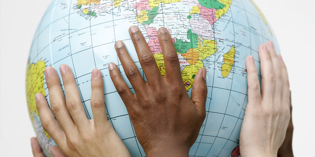 student hands holding globe