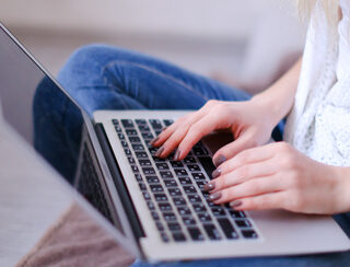 Closeup woman hands typing on laptop keyboard.