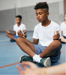 students meditating in gym class
